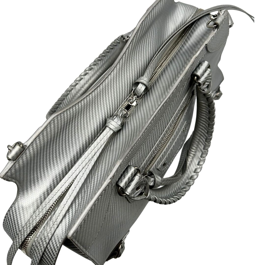 chiusura Borsa Balenciaga in pelle color argento metallizzato con parti metalliche tono su tono; munita di doppi manici stondati e una tracolla amovibile e regolabile. Completa di dustbag, di lusso, originale, ottime condizioni.