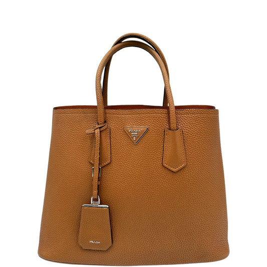 front Borsa Prada in pelle color cammello e parti metalliche argentate; munita di doppi manici stondati e di un accessorio porta address. Completa di dustbag, di lusso, originale, ottime condizioni. 