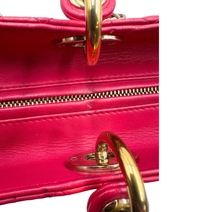 Parte superiore di una borsa Lady Dior Large in pelle fucsia in trama cannage. Doppi manici rigidi, con parti metalliche dorate. Completa di dustbag. Indossabile a mano.