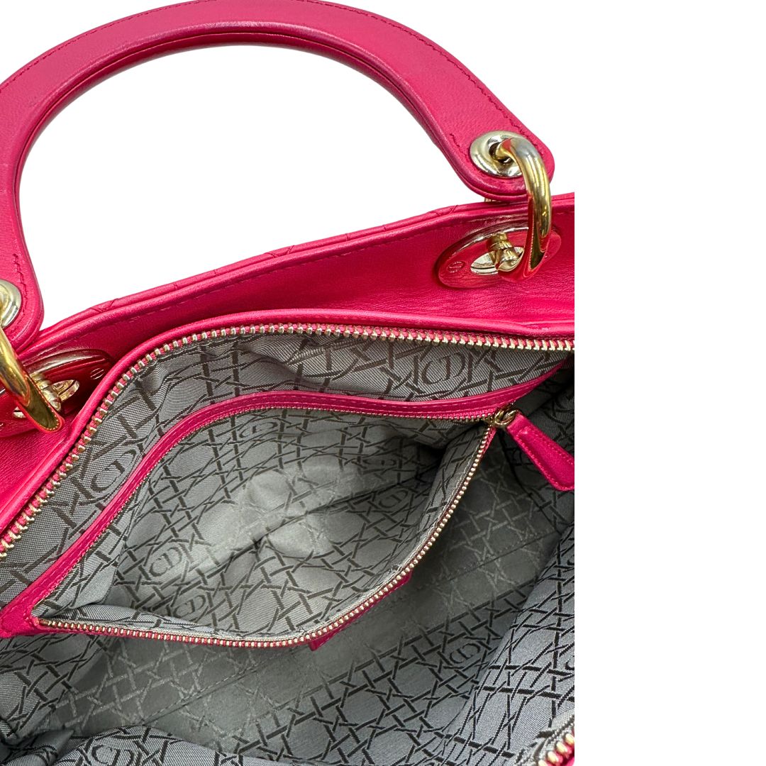 Interno di una borsa Lady Dior Large in pelle fucsia in trama cannage. Doppi manici rigidi, con parti metalliche dorate. Completa di dustbag. Indossabile a mano.