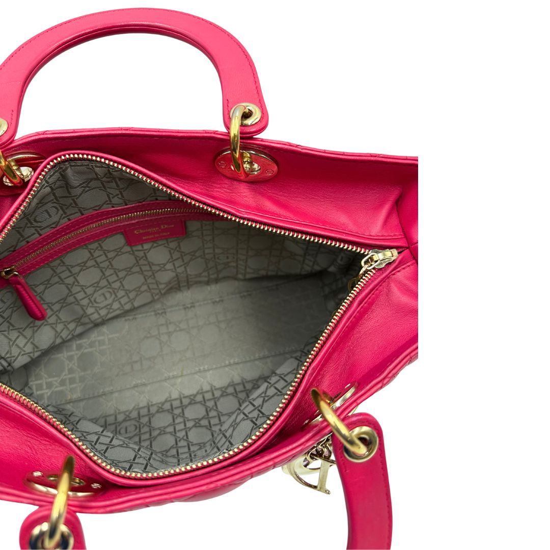 Interno di una borsa Lady Dior Large in pelle fucsia in trama cannage. Doppi manici rigidi, con parti metalliche dorate. Completa di dustbag. Indossabile a mano.