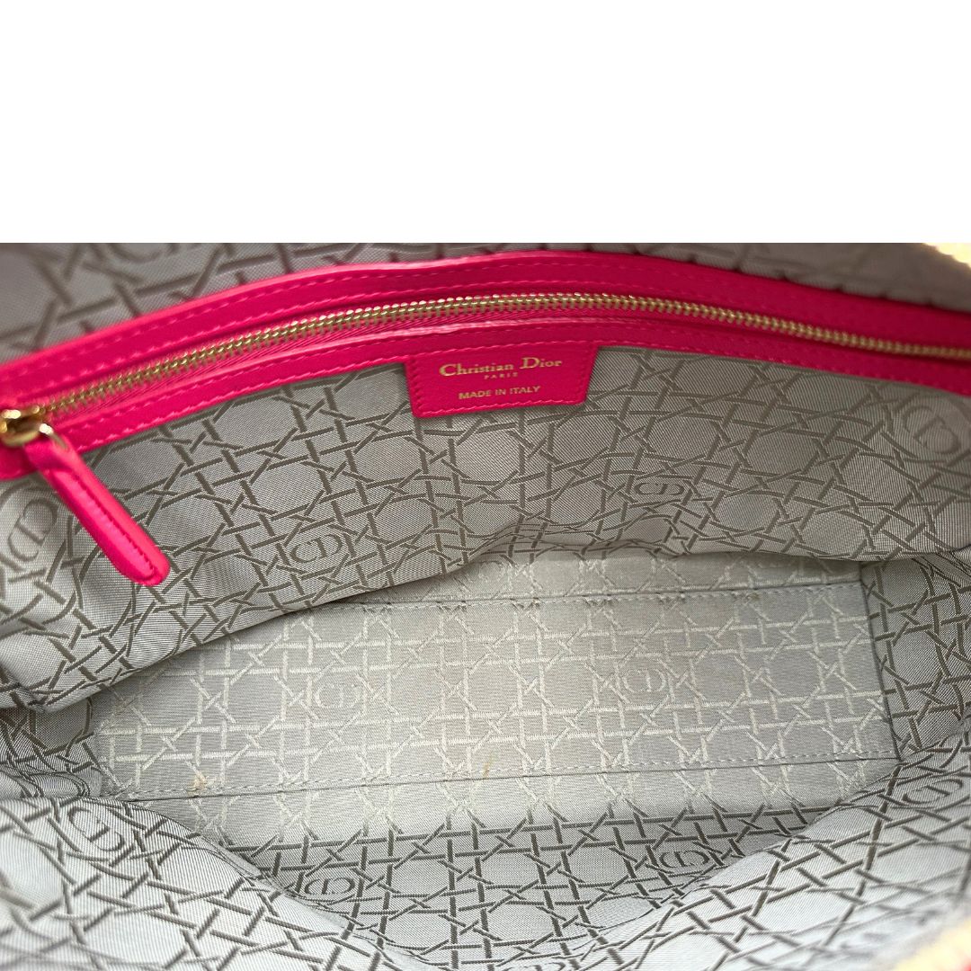 Interno di una borsa Lady Dior Large in pelle fucsia in trama cannage. Doppi manici rigidi, con parti metalliche dorate. Completa di dustbag. Indossabile a mano.