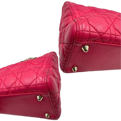 Angoli di una borsa Lady Dior Large in pelle fucsia in trama cannage. Doppi manici rigidi, con parti metalliche dorate. Completa di dustbag. Indossabile a mano.