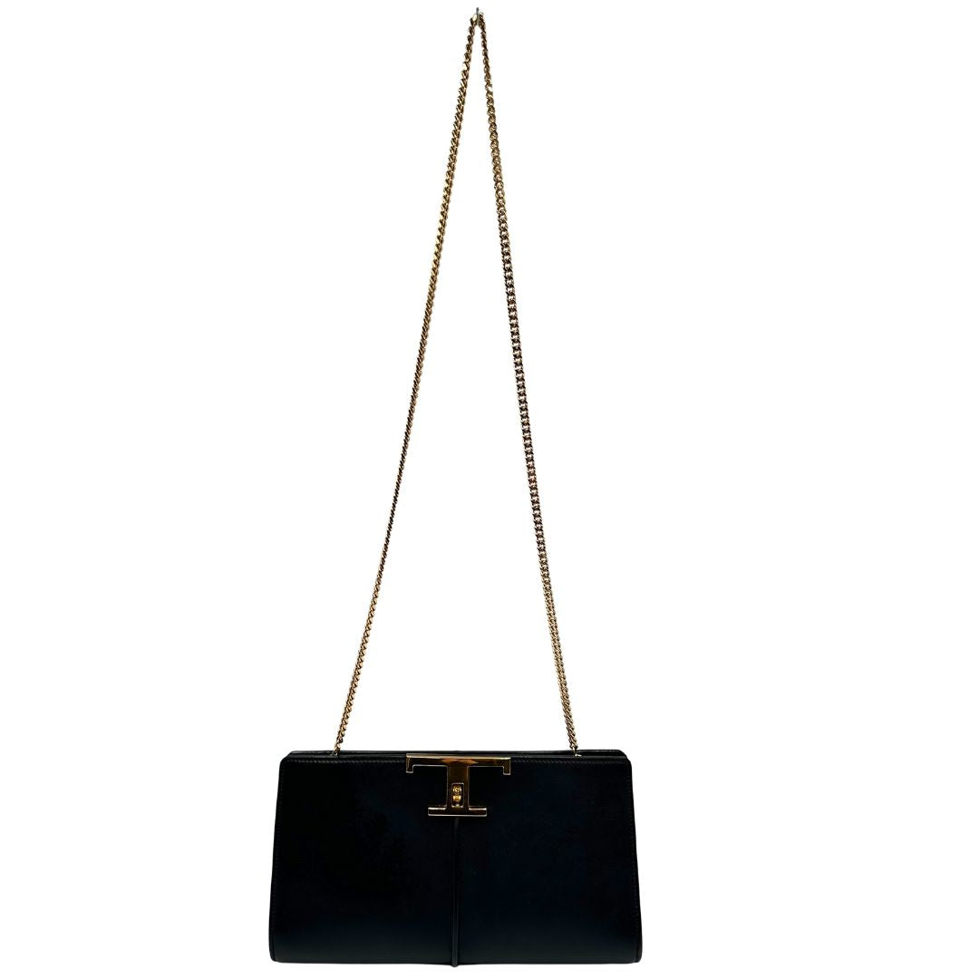 Front di una borsa Tod's in pelle nera con parti metalliche dorate; munita di una tracolla in catena non amovibile e non regolabile e di un polsino staccabile in pelle. Completa di doppie dustbag.