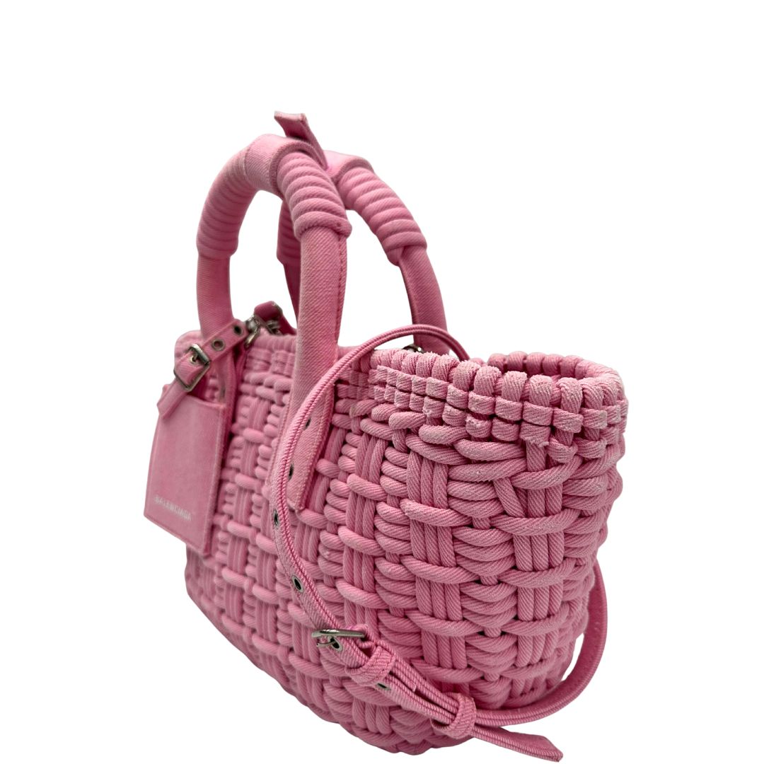 Laterale destro di una borsa Balenciaga in tessuto a maxi intreccio color rosa bubblegum con parti metalliche argentate; munita di doppi manici stondati, una tracolla amovibile e regolabile e un porta address. Completa di dustbag e cartellini.