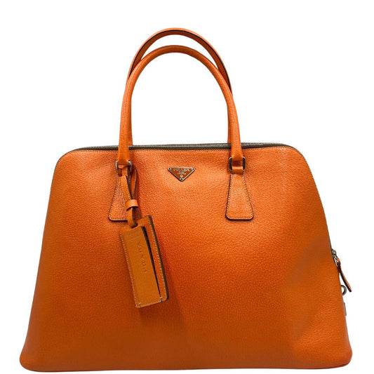 Front di una Borsa Prada Promenade in pelle arancione papaya. Munita di doppi manici stondati, porta address rimovibile e parti metalliche argentate. Completa di lucchetto e chiavi.
