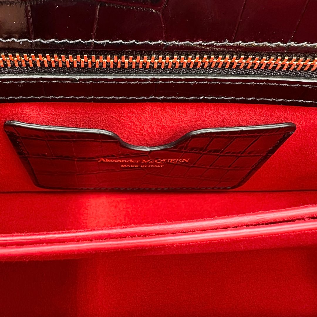 interno Borsa Alexander McQueen in pelle cocco nera con parti metalliche dorate; munita di una tracolla scorrevole in catena con spallaccio in pelle e una knuckle handle impreziosita da teschi e diamanti incastonati. Completa di dustbag, di lusso, originale, eccellenti condizioni