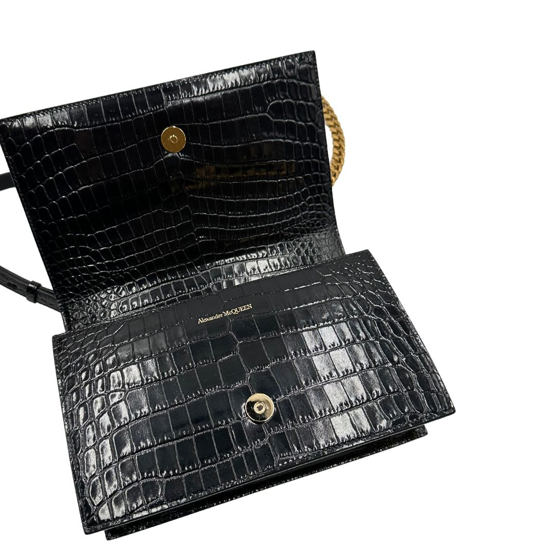 interno Borsa Alexander McQueen in pelle cocco nera con parti metalliche dorate; munita di una tracolla scorrevole in catena con spallaccio in pelle e una knuckle handle impreziosita da teschi e diamanti incastonati. Completa di dustbag, di lusso, originale, eccellenti condizioni
