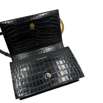 interno Borsa Alexander McQueen in pelle cocco nera con parti metalliche dorate; munita di una tracolla scorrevole in catena con spallaccio in pelle e una knuckle handle impreziosita da teschi e diamanti incastonati. Completa di dustbag, di lusso, originale, eccellenti condizioni