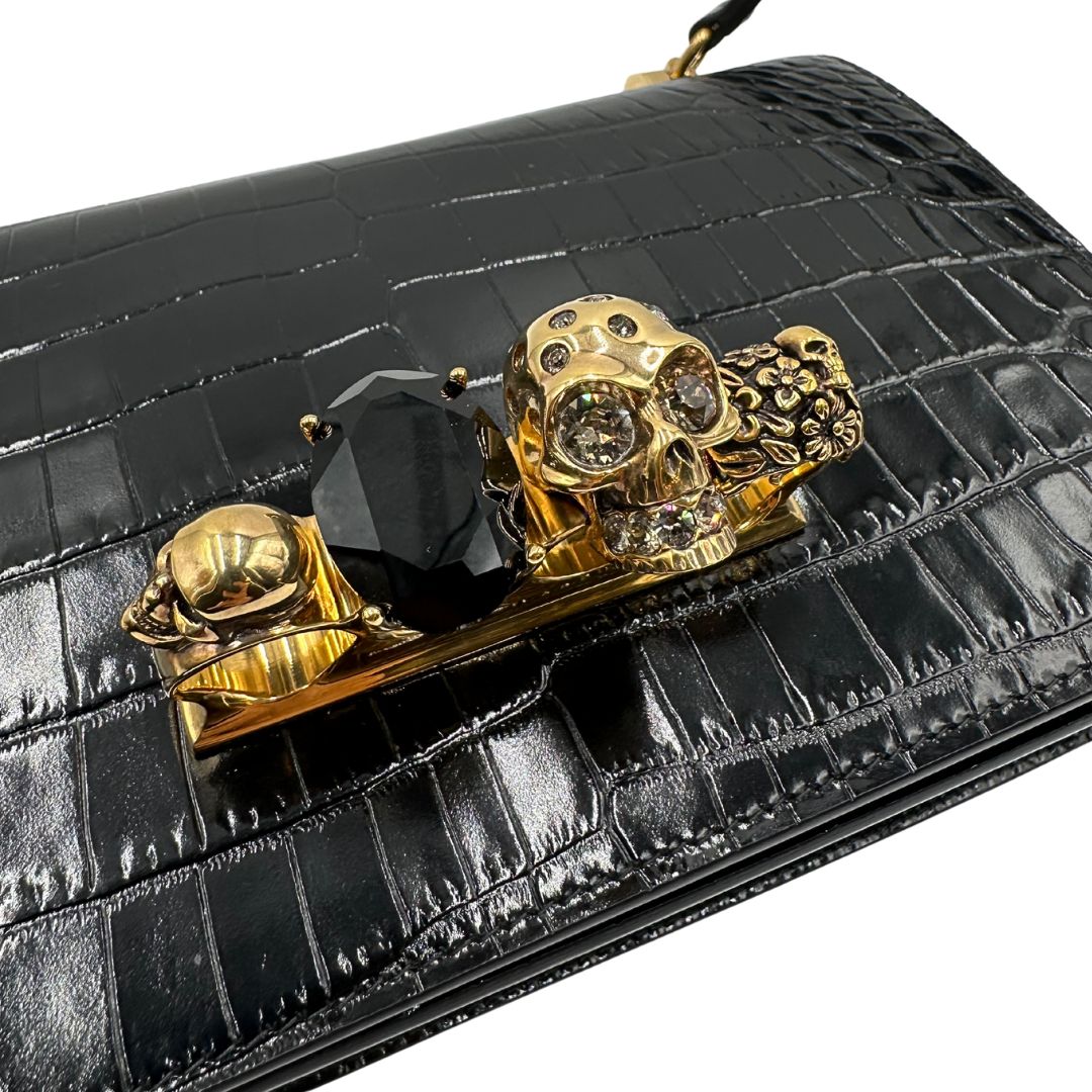 Borsa Alexander McQueen in pelle cocco nera con parti metalliche dorate; munita di una tracolla scorrevole in catena con spallaccio in pelle e una knuckle handle impreziosita da teschi e diamanti incastonati. Completa di dustbag, di lusso, originale, eccellenti condizioni
