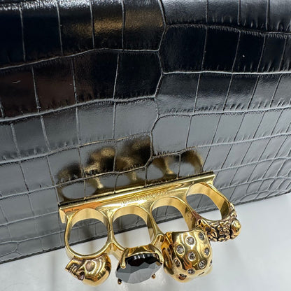 Borsa Alexander McQueen in pelle cocco nera con parti metalliche dorate; munita di una tracolla scorrevole in catena con spallaccio in pelle e una knuckle handle impreziosita da teschi e diamanti incastonati. Completa di dustbag, di lusso, originale, eccellenti condizioni