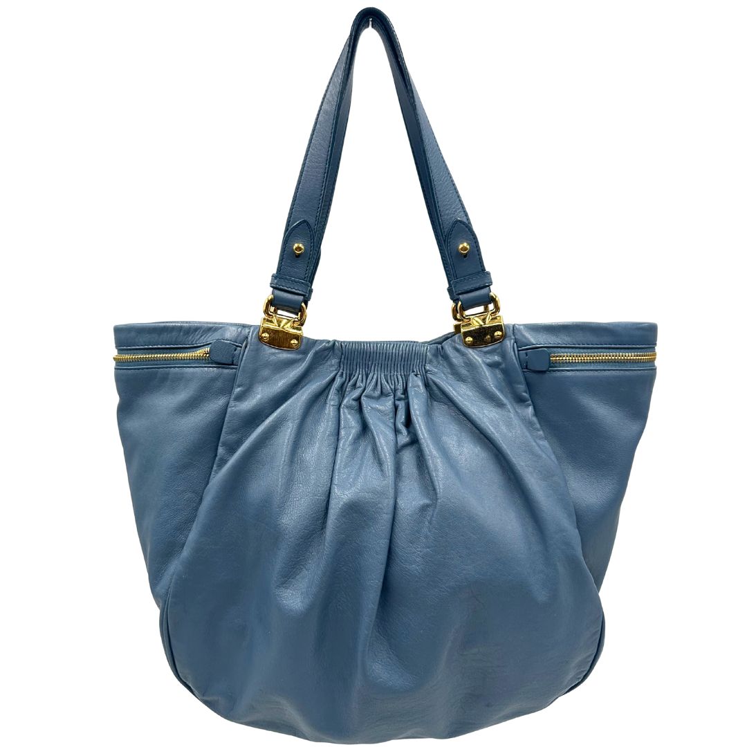 front Borsa Miu Miu in pelle blu con parti metalliche dorate; munita di doppi manici, indossabile a spalla. Completa di dustbag, di lusso, originale, ottime condizioni. 