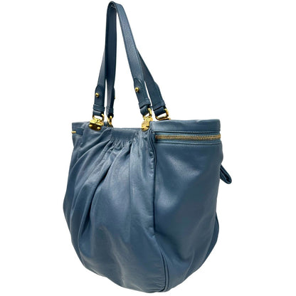 lato Borsa Miu Miu in pelle blu con parti metalliche dorate; munita di doppi manici, indossabile a spalla. Completa di dustbag, di lusso, originale, ottime condizioni. 