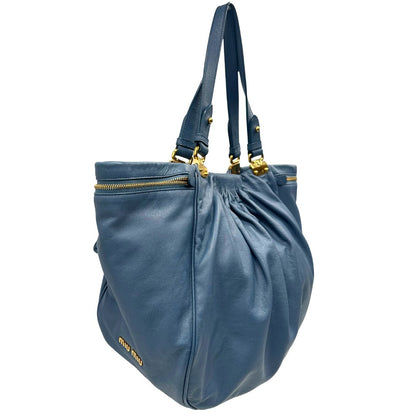 lato Borsa Miu Miu in pelle blu con parti metalliche dorate; munita di doppi manici, indossabile a spalla. Completa di dustbag, di lusso, originale, ottime condizioni. 