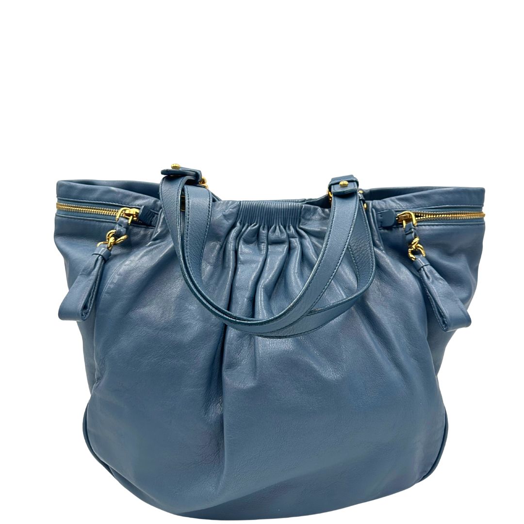retro Borsa Miu Miu in pelle blu con parti metalliche dorate; munita di doppi manici, indossabile a spalla. Completa di dustbag, di lusso, originale, ottime condizioni. 