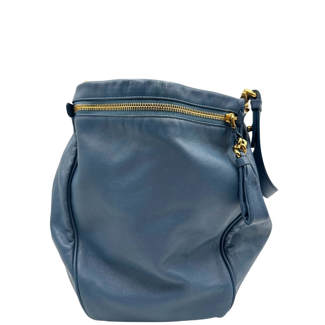 laterale Borsa Miu Miu in pelle blu con parti metalliche dorate; munita di doppi manici, indossabile a spalla. Completa di dustbag, di lusso, originale, ottime condizioni. 