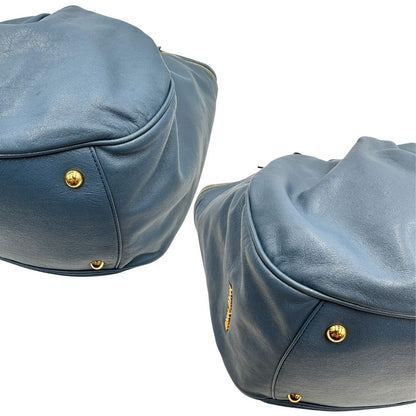 angoli Borsa Miu Miu in pelle blu con parti metalliche dorate; munita di doppi manici, indossabile a spalla. Completa di dustbag, di lusso, originale, ottime condizioni.