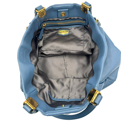 interno Borsa Miu Miu in pelle blu con parti metalliche dorate; munita di doppi manici, indossabile a spalla. Completa di dustbag, di lusso, originale, ottime condizioni. 