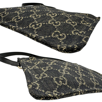 Angoli di un accessorio pochette Gucci in denim nero trama GG con dettagli in pelle neri. Parti metalliche dorate. Completa di dustbag.