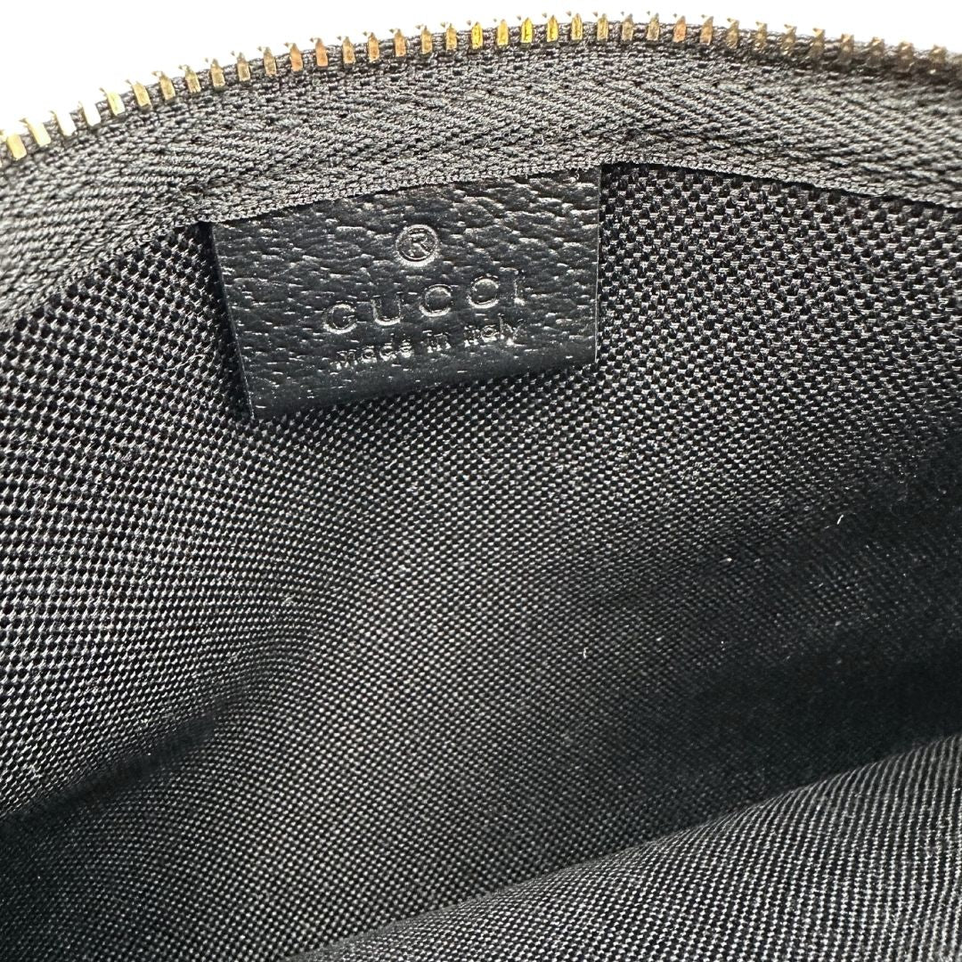 Interno di un accessorio pochette Gucci in denim nero trama GG con dettagli in pelle neri. Parti metalliche dorate. Completa di dustbag.