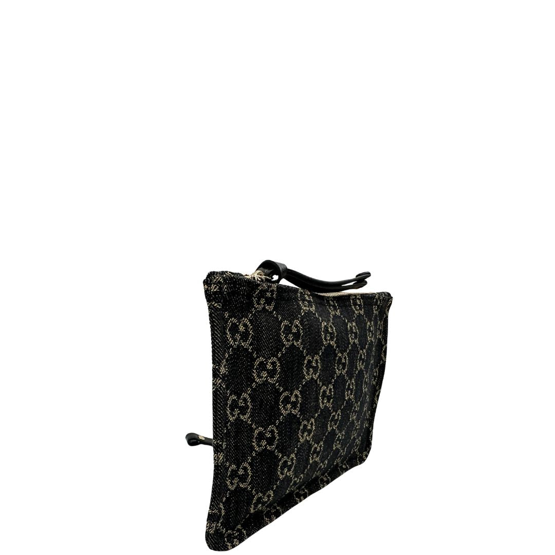 Laterale sinistro di un accessorio pochette Gucci in denim nero trama GG con dettagli in pelle neri. Parti metalliche dorate. Completa di dustbag.