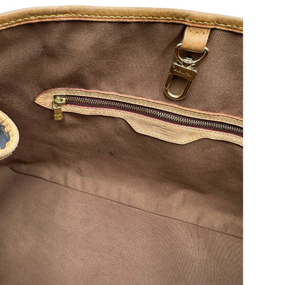 Interno di una borsa LV in canvas marrone monogram con finiture in vacchetta naturale e dettagli metallici dorati. Dotata di dustbag.