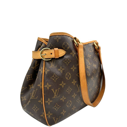 Laterale sinistro di una borsa LV in canvas marrone monogram con finiture in vacchetta naturale e dettagli metallici dorati. Dotata di dustbag.