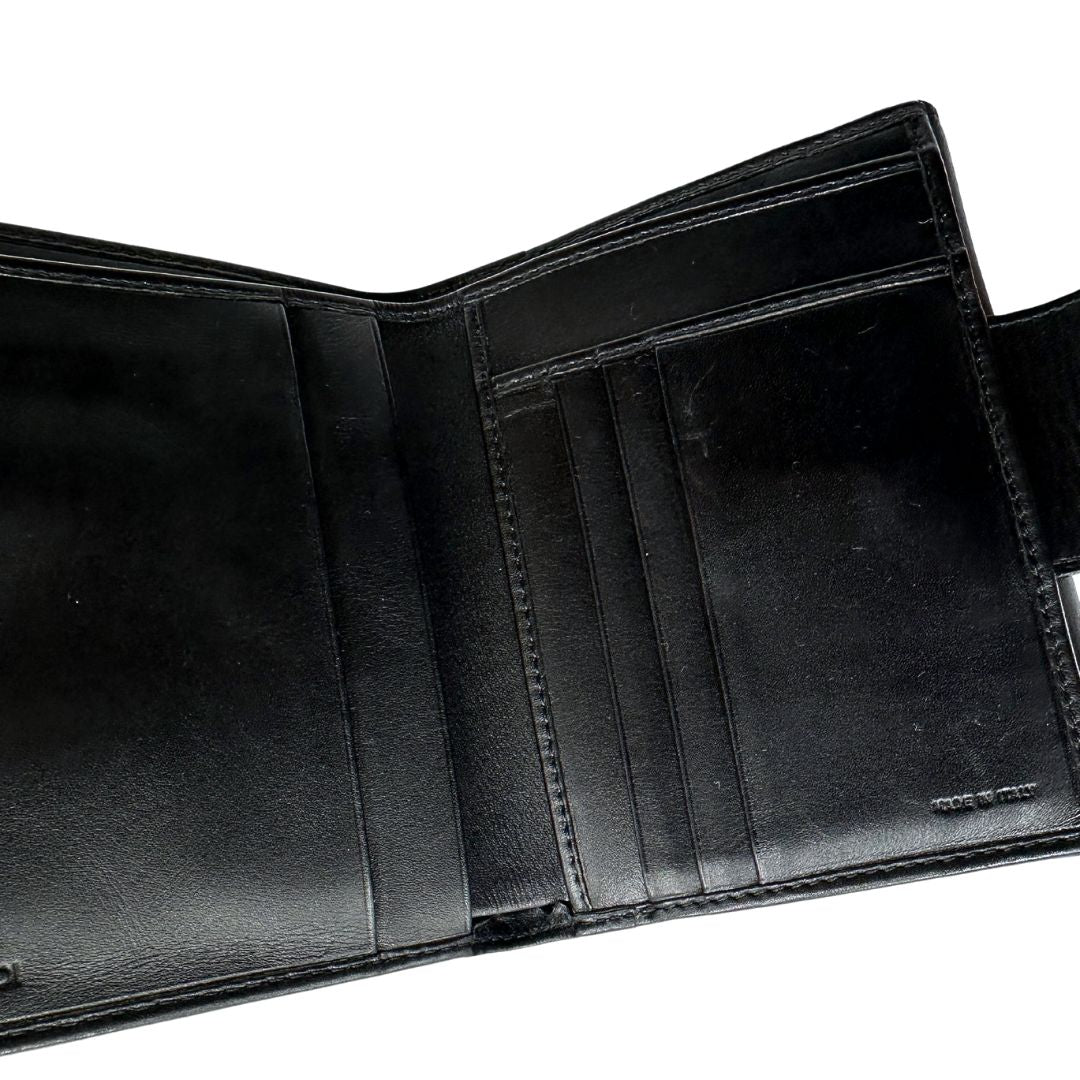 Interno di un portafoglio Fendi in pelle nera con logo doppie F sul front e con parti metalliche argentate.