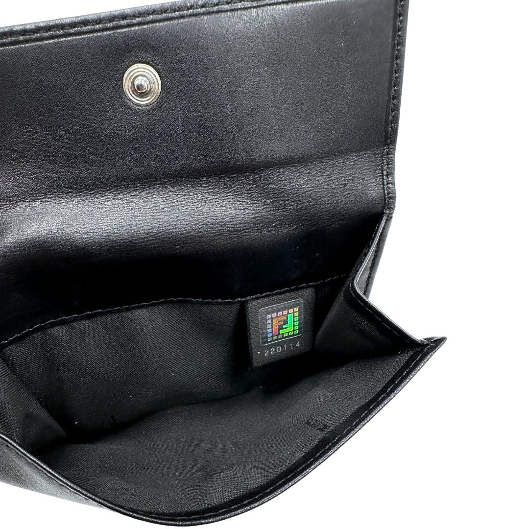 Interno di un portafoglio Fendi in pelle nera con logo doppie F sul front e con parti metalliche argentate.