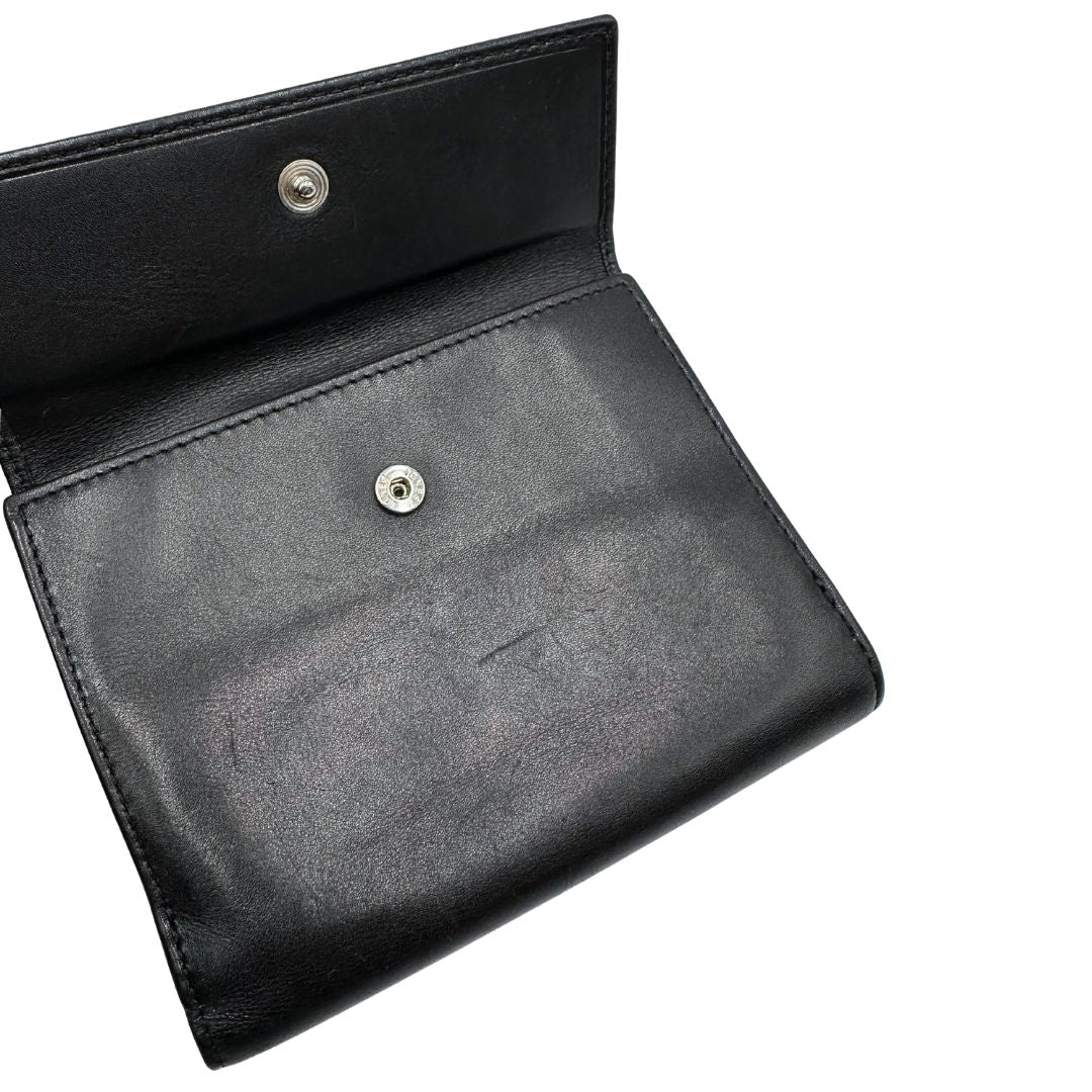 Interno di un portafoglio Fendi in pelle nera con logo doppie F sul front e con parti metalliche argentate.