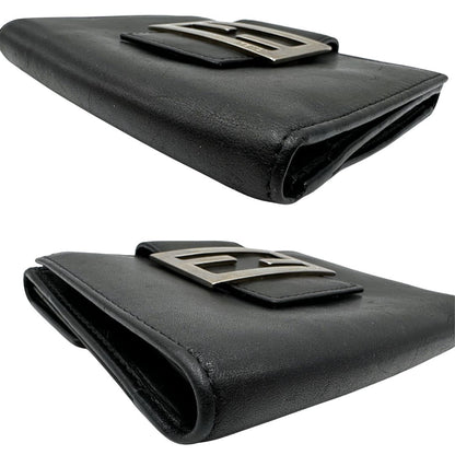 Angoli di un portafoglio Fendi in pelle nera con logo doppie F sul front e con parti metalliche argentate.