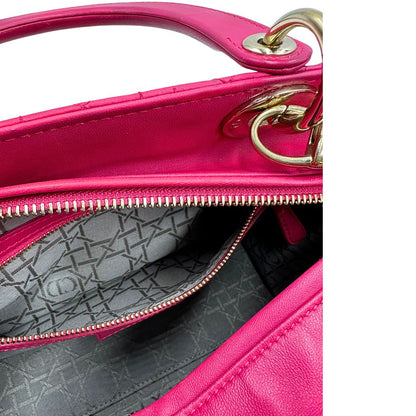 interno Borsa Lady Dior in pelle cannage fucsia con parti metalliche dorate; munita di doppi manici e una tracolla amovibile. Completa di dustbag, di lusso, originale, ottime condizioni. 