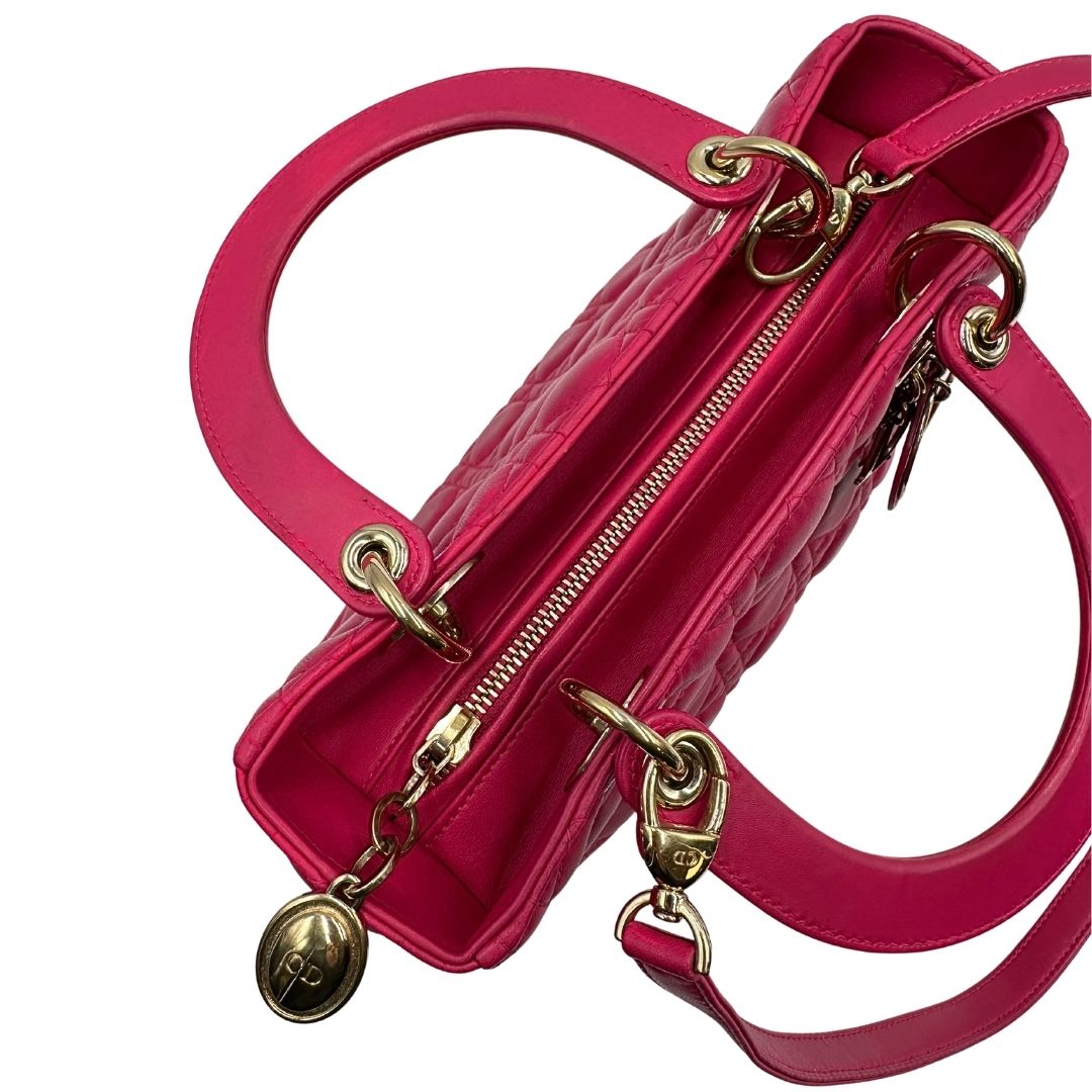cerniera Borsa Lady Dior in pelle cannage fucsia con parti metalliche dorate; munita di doppi manici e una tracolla amovibile. Completa di dustbag, di lusso, originale, ottime condizioni. 