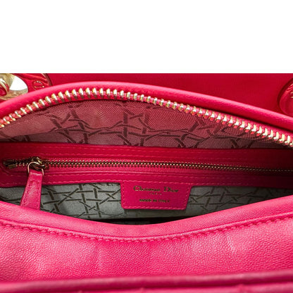 interno Borsa Lady Dior in pelle cannage fucsia con parti metalliche dorate; munita di doppi manici e una tracolla amovibile. Completa di dustbag, di lusso, originale, ottime condizioni. 