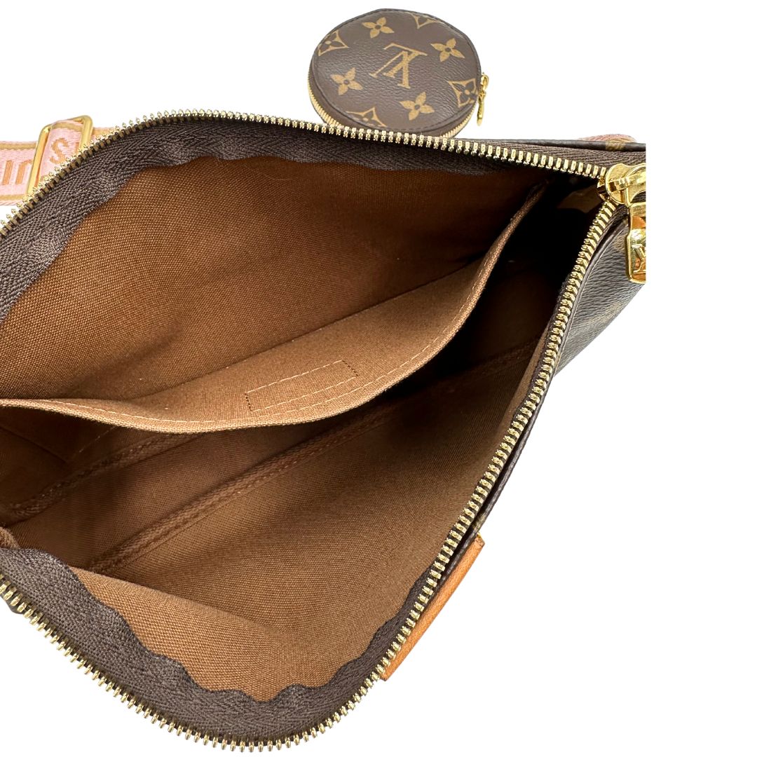 Interno di una Multi Pochette Accessoires Louis Vuitton in canvas marrone monogram con dettagli in vacchetta naturale, manico in catena dorata e tracolla in tessuto Jacquard rosa. Dotata del classico mini portamonete rotondo, rimovibile. Munita di scatola.