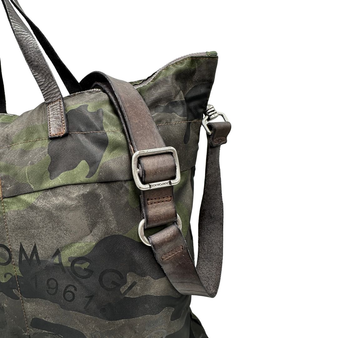 Tracolla di una tote Campomaggi in nylon trama camouflage, con finiture in pelle testa di moro e parti metalliche argentate. Munita di tracolla amovibile e regolabile. Completa di dustbag.