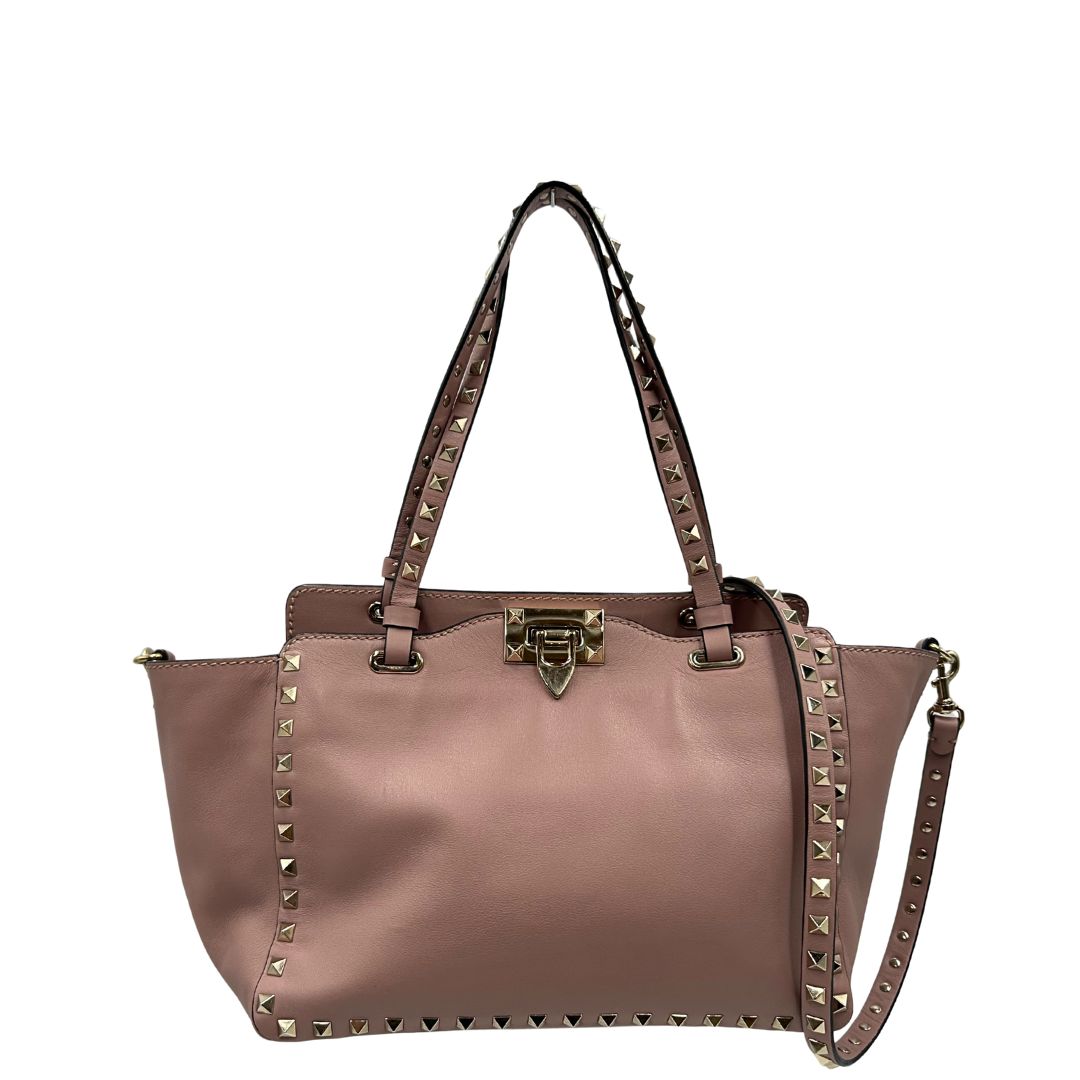 front Borsa Valentino Garavani in pelle rosa con parti metalliche dorate; impreziosita da borchie piramidali e munita di doppi manici e una tracolla amovibile. Completa di dustbag, di lusso, originale, usata. 