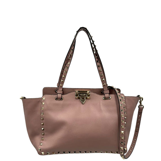 front Borsa Valentino Garavani in pelle rosa con parti metalliche dorate; impreziosita da borchie piramidali e munita di doppi manici e una tracolla amovibile. Completa di dustbag, di lusso, originale, usata. 