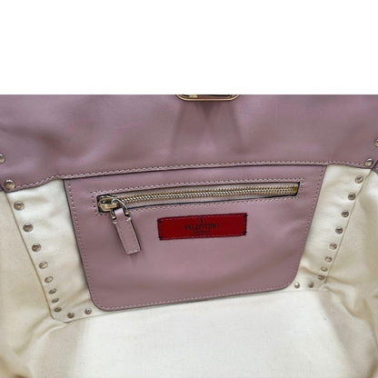 interno Borsa Valentino Garavani in pelle rosa con parti metalliche dorate; impreziosita da borchie piramidali e munita di doppi manici e una tracolla amovibile. Completa di dustbag, di lusso, originale, usata. 