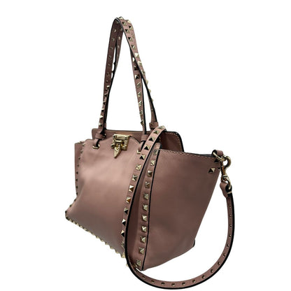 lato Borsa Valentino Garavani in pelle rosa con parti metalliche dorate; impreziosita da borchie piramidali e munita di doppi manici e una tracolla amovibile. Completa di dustbag, di lusso, originale, usata. 