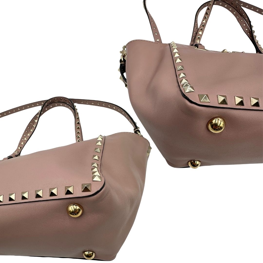 angoli Borsa Valentino Garavani in pelle rosa con parti metalliche dorate; impreziosita da borchie piramidali e munita di doppi manici e una tracolla amovibile. Completa di dustbag, di lusso, originale, usata. 