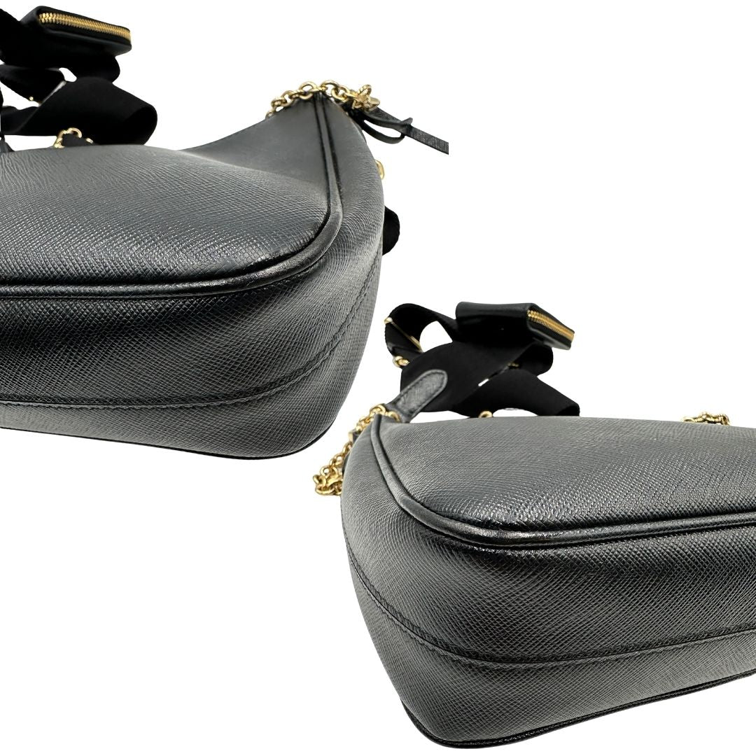 Angoli di una borsa Prada in pelle saffiano nera, con parti metalliche dorate. Dotata di una tracolla in tessuto regolabile ed amovibile, con pouch porta monete removibile e di una tracollina in catena. Munita di clochette porta chiavi. Indossabile a spalla o a tracolla. Full set.