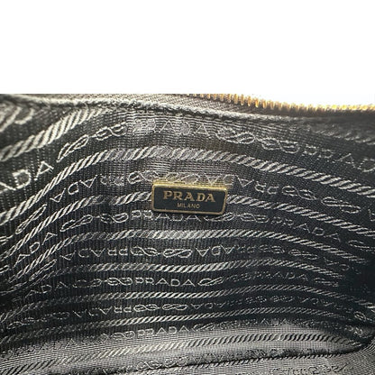 Interno di una borsa Prada in pelle saffiano nera, con parti metalliche dorate. Dotata di una tracolla in tessuto regolabile ed amovibile, con pouch porta monete removibile e di una tracollina in catena. Munita di clochette porta chiavi. Indossabile a spalla o a tracolla. Full set.