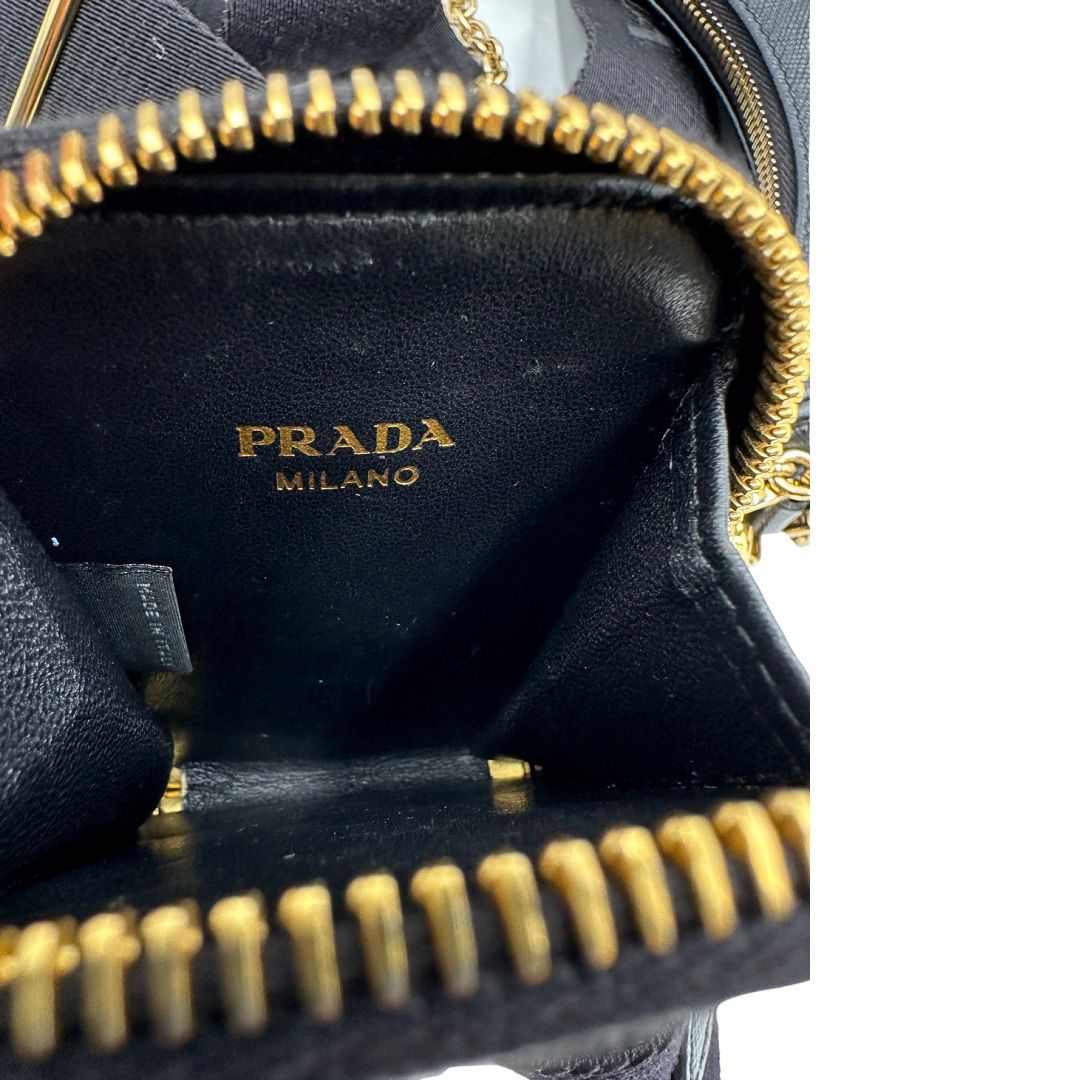 Interno del pouch di una borsa Prada in pelle saffiano nera, con parti metalliche dorate. Dotata di una tracolla in tessuto regolabile ed amovibile e di una tracollina in catena. Munita di clochette porta chiavi. Indossabile a spalla o a tracolla. Full set.