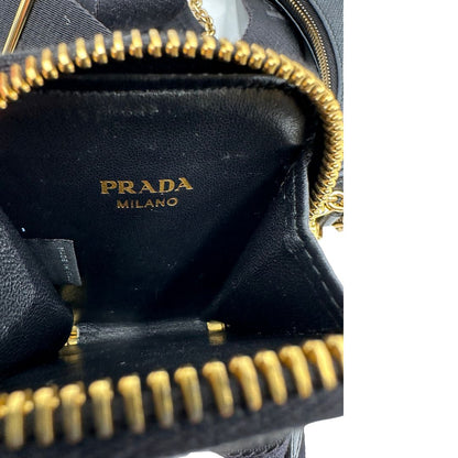 Interno del pouch di una borsa Prada in pelle saffiano nera, con parti metalliche dorate. Dotata di una tracolla in tessuto regolabile ed amovibile e di una tracollina in catena. Munita di clochette porta chiavi. Indossabile a spalla o a tracolla. Full set.