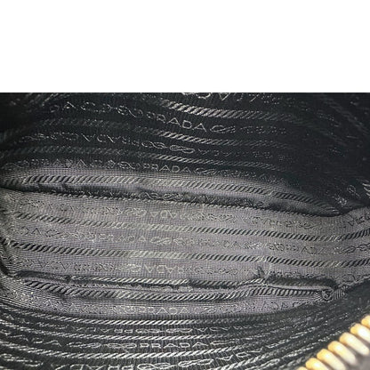 Interno di una borsa Prada in pelle saffiano nera, con parti metalliche dorate. Dotata di una tracolla in tessuto regolabile ed amovibile, con pouch porta monete removibile e di una tracollina in catena. Munita di clochette porta chiavi. Indossabile a spalla o a tracolla. Full set.