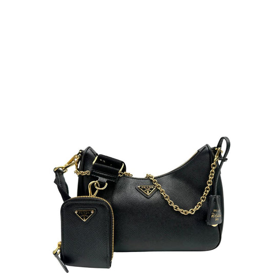 Front di una borsa Prada in pelle saffiano nera, con parti metalliche dorate. Dotata di una tracolla in tessuto regolabile ed amovibile, con pouch porta monete removibile e di una tracollina in catena. Munita di clochette porta chiavi. Indossabile a spalla o a tracolla. Full set.