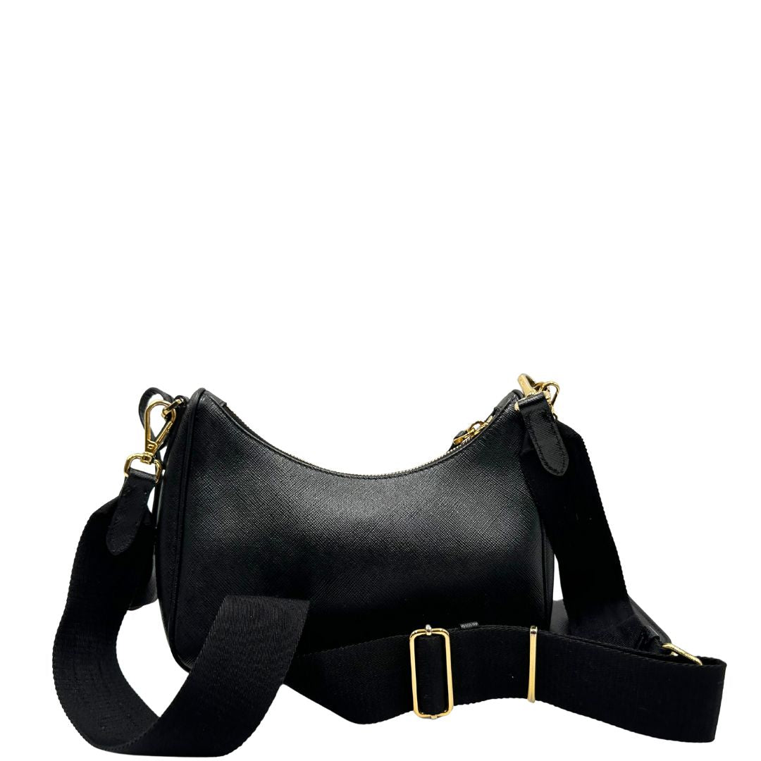 Retro di una borsa Prada in pelle saffiano nera, con parti metalliche dorate. Dotata di una tracolla in tessuto regolabile ed amovibile, con pouch porta monete removibile e di una tracollina in catena. Munita di clochette porta chiavi. Indossabile a spalla o a tracolla. Full set.