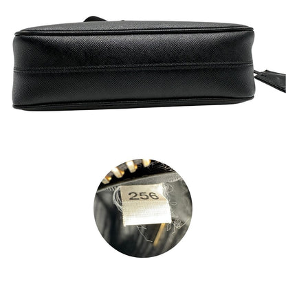 Base e codice di una borsa Prada in pelle saffiano nera, con parti metalliche dorate. Dotata di una tracolla in tessuto regolabile ed amovibile, con pouch porta monete removibile e di una tracollina in catena. Munita di clochette porta chiavi. Indossabile a spalla o a tracolla. Full set.