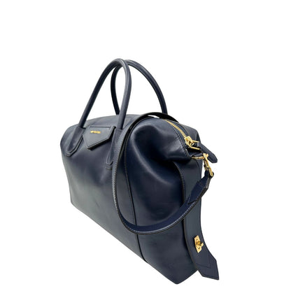 Lato sinistro di una Borsa Givenchy Antigona in pelle blu notte munita di doppi manici stondati, Parti metalliche dorate e una tracolla amovibile. Completa di dustbag. Originale, usata, di lusso, in ottime condizioni.